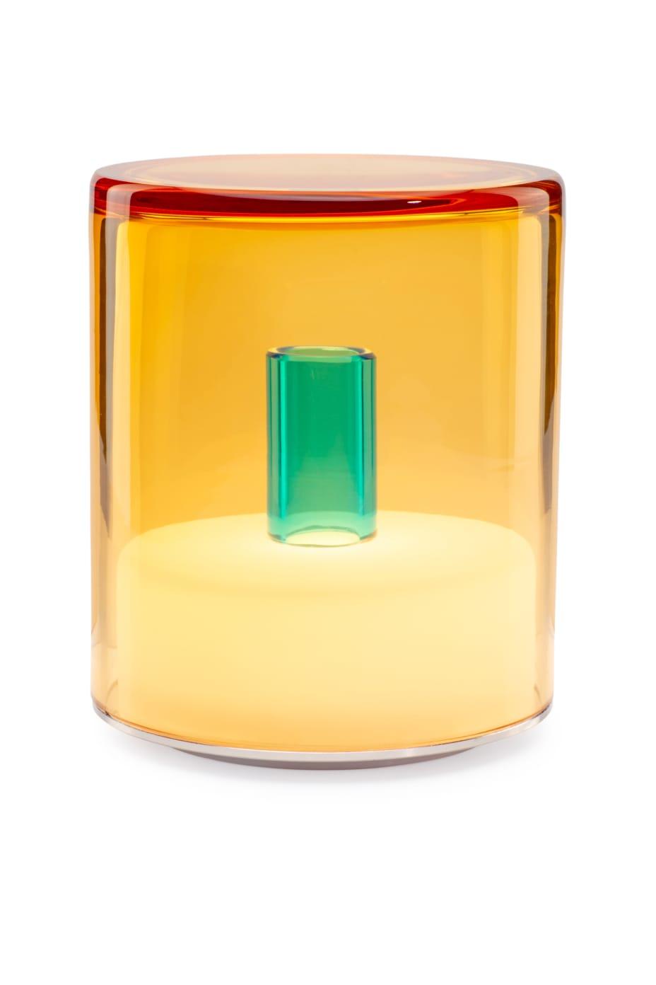 Multicolored cylindrical glass object on a white background