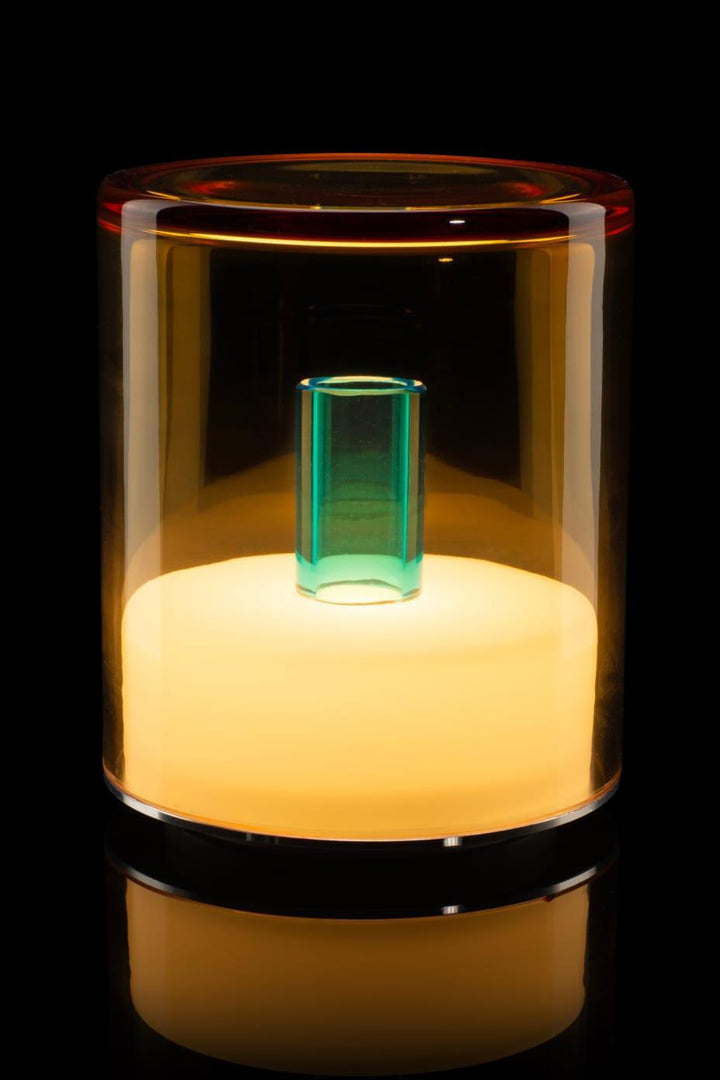 Glass container with a glowing green object inside on a black background