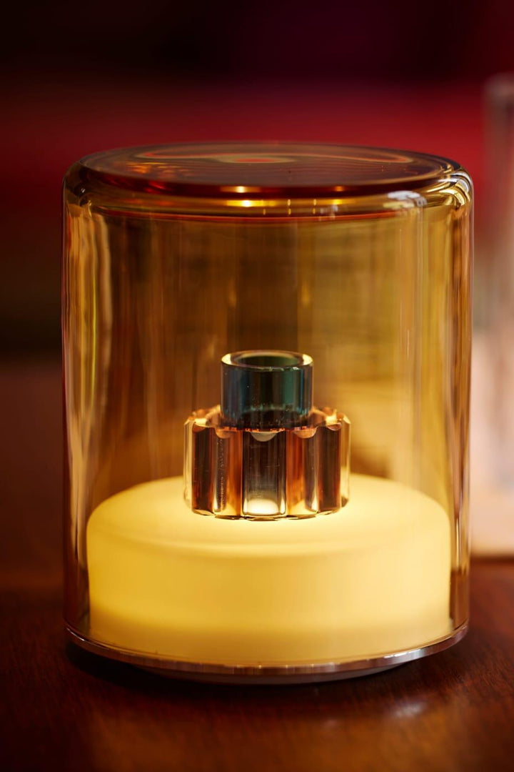 Glass container with a light bulb inside on a wooden surface