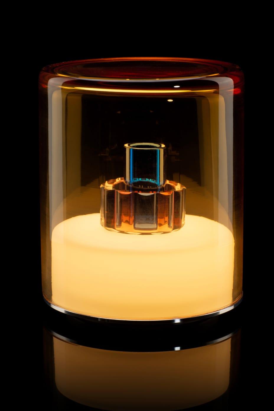 Glass container with a cylindrical object inside on a black background
