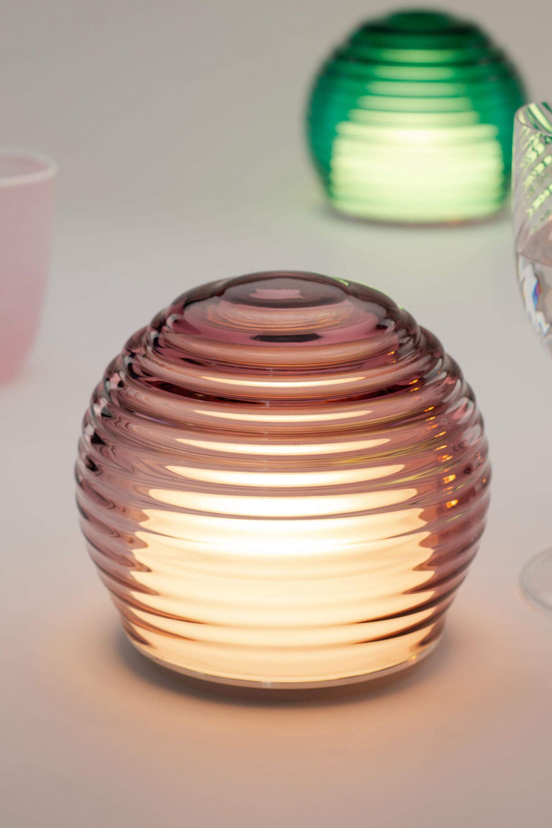 Decorative glass lantern with ribbed design on a light background