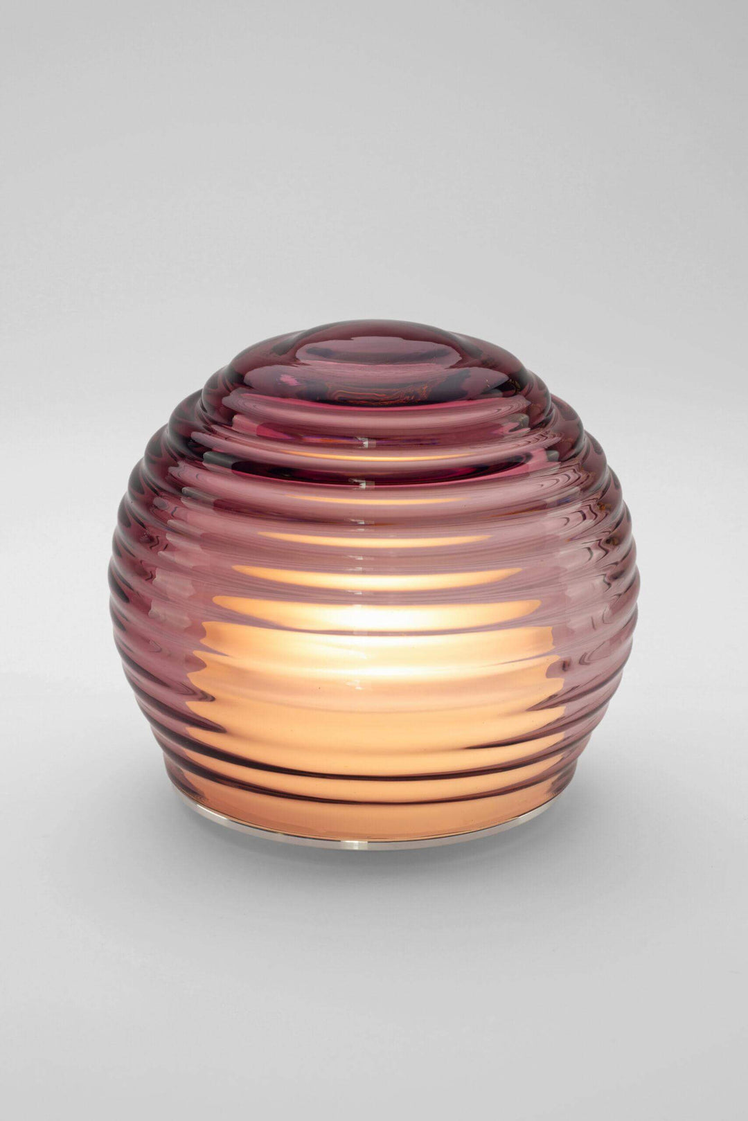 Glass candle holder with ribbed design on a gray background