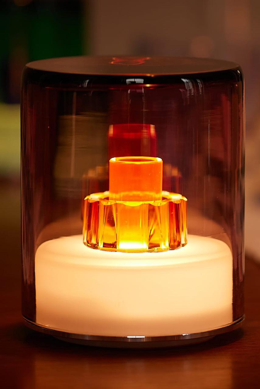 Decorative lamp with a glass cover and glowing interior on a blurred background