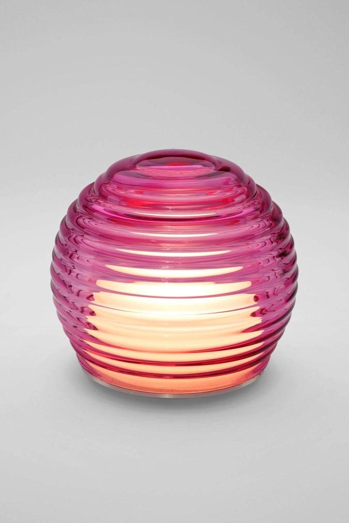 Pink glass lantern with ribbed texture on a gray background