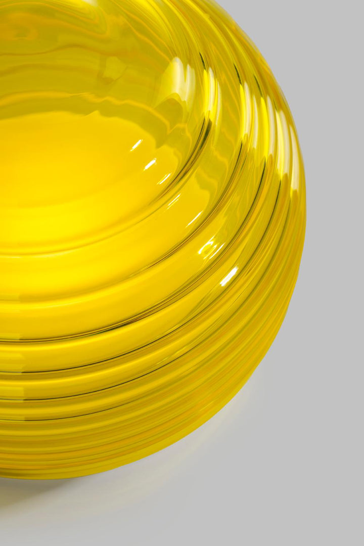 Close-up of a yellow glass bowl on a light gray background