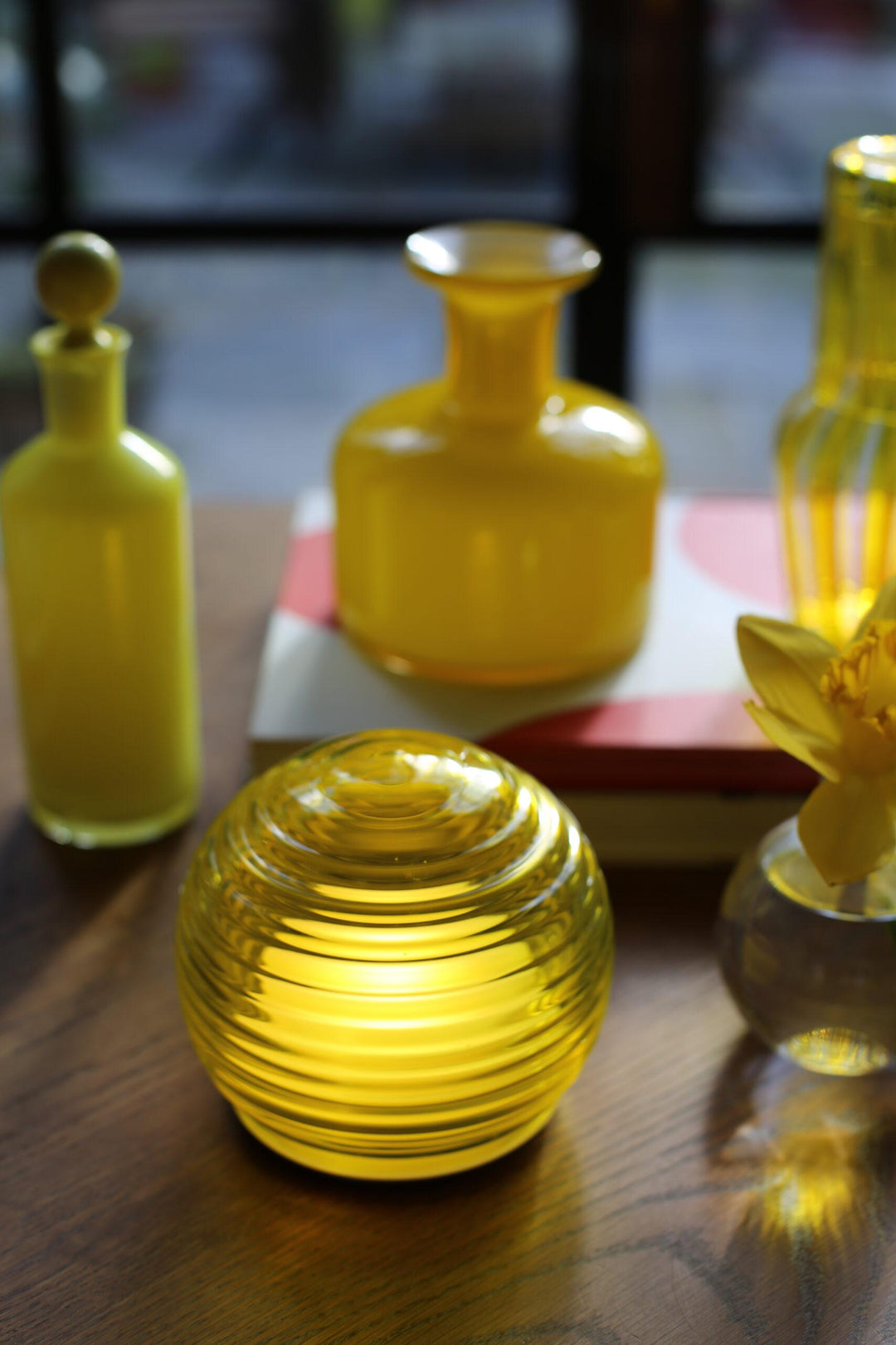 Yellow glass bottles on a wooden surface with a blurred background